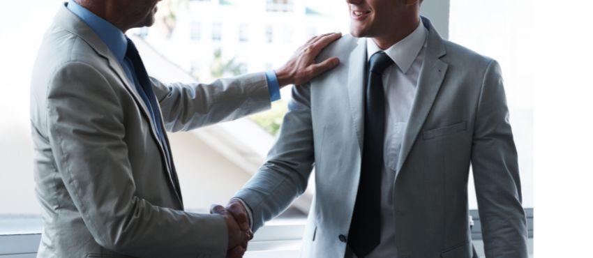 two men shaking hands after a sale