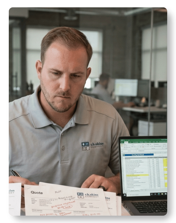 Manual quoting challenges shown as HVAC sales professional reviews spreadsheets, printed quotes, and handwritten pricing adjustments